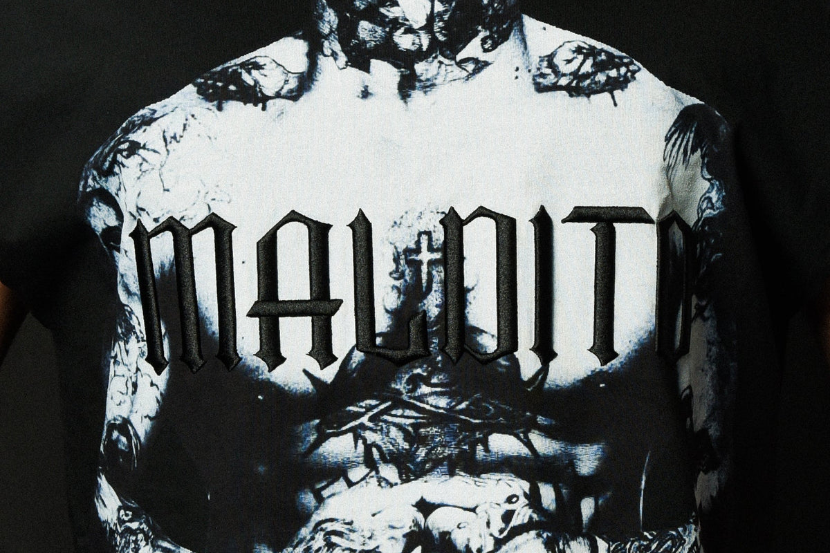 Close-up detail of the embroidery on the MALDITO cut-off tee showing texture and stitching.