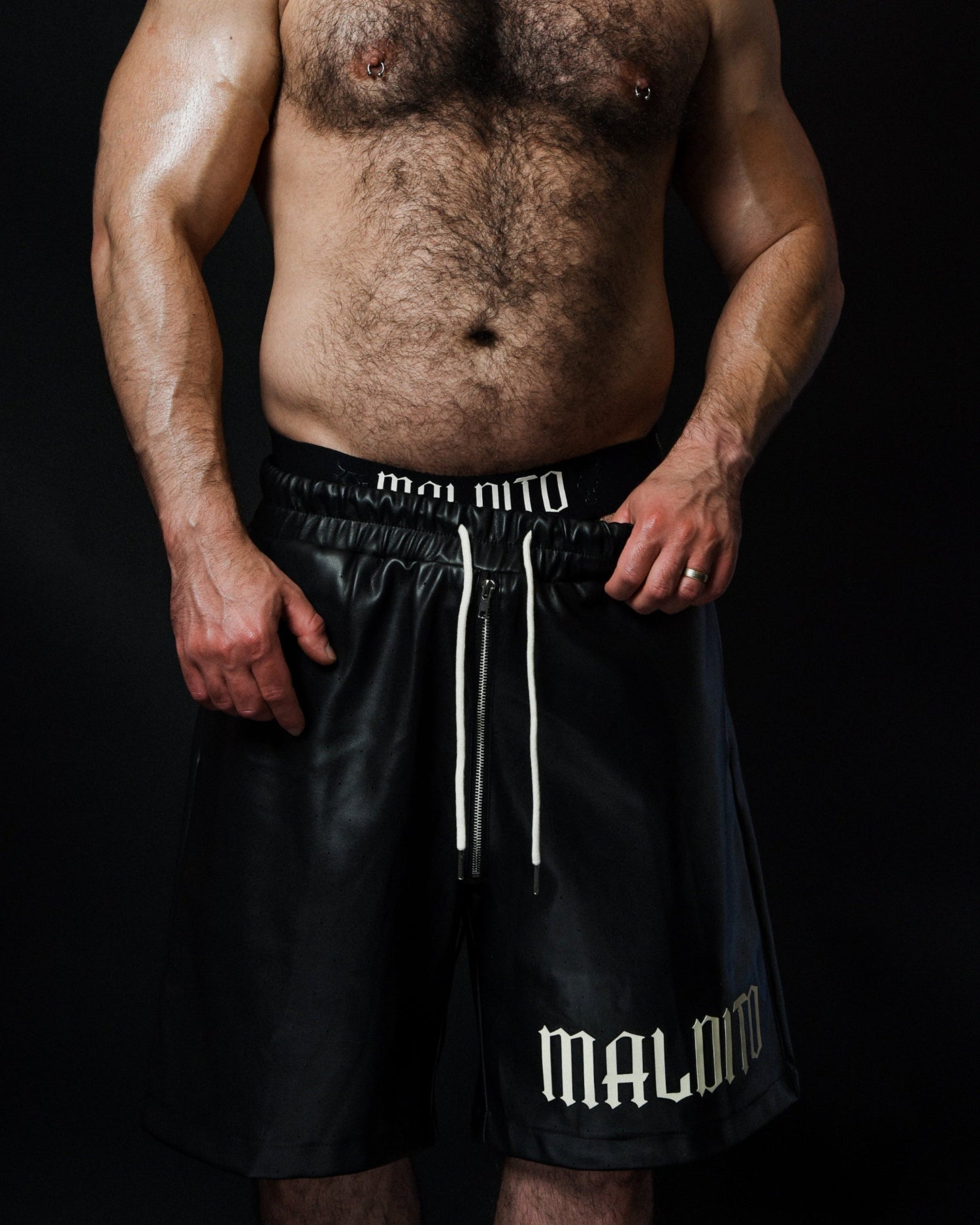 Front view of model pulling side of MALDITO Restraint leather shorts